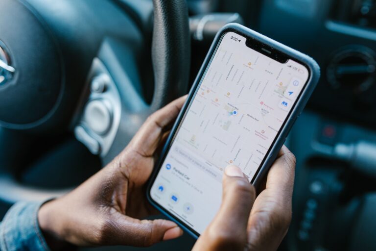 Motorista de aplicativo verificando corrida no celular dentro do carro