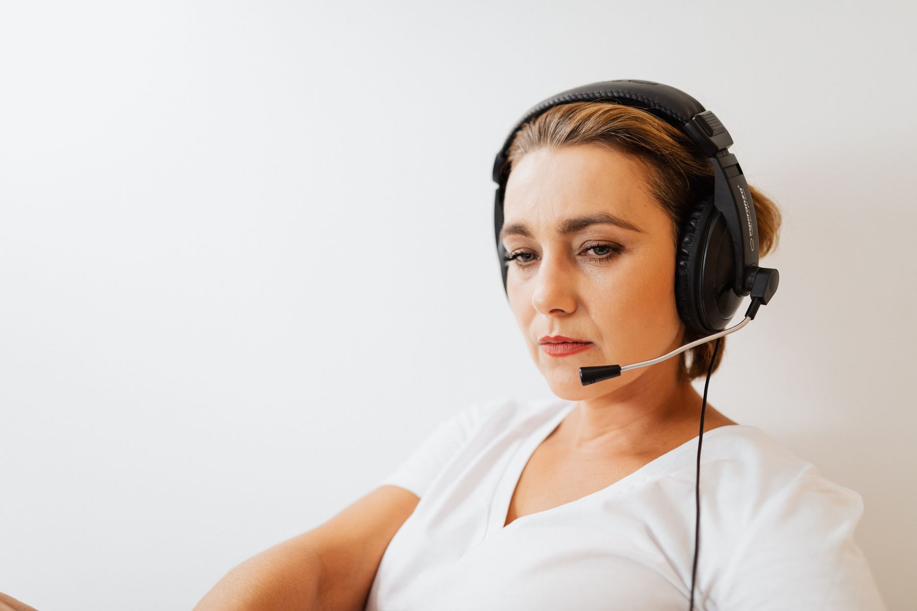 Trabalhadora terceirizada de call center atendendo cliente com headset