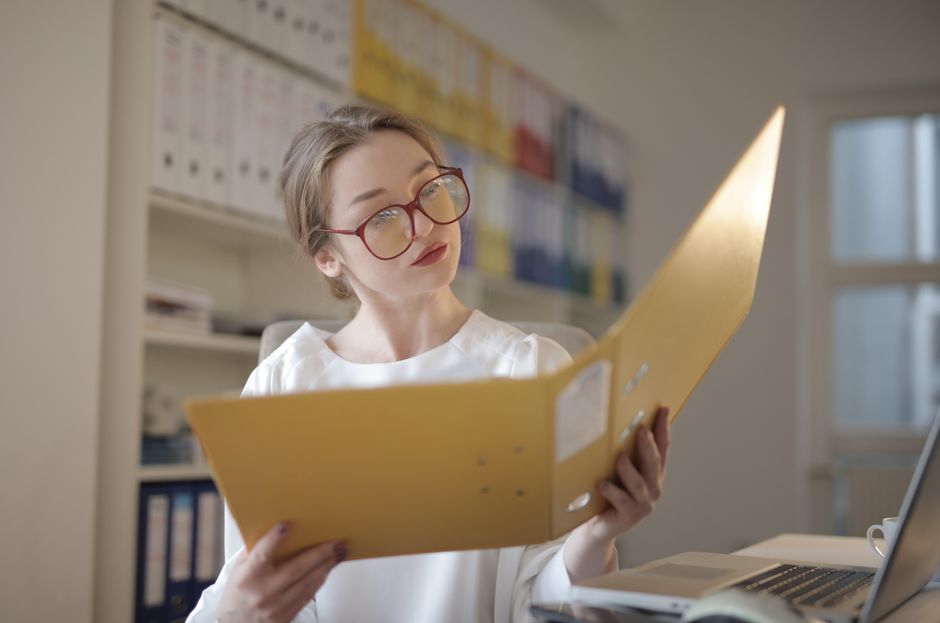 Mulher lendo documentos atentamente no escritório