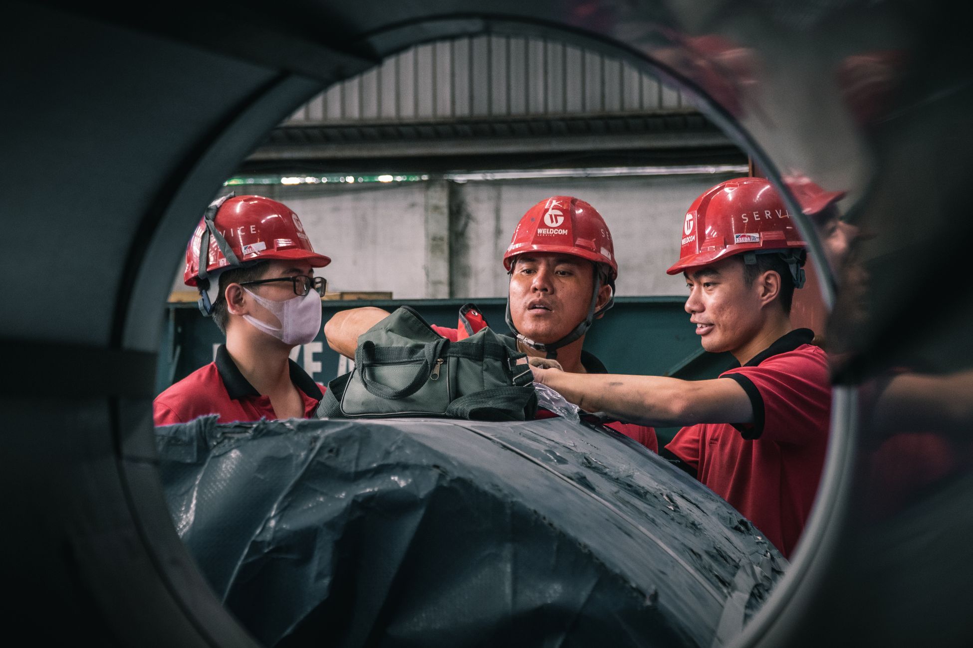 Trabalhadores usando capacete e equipamento de proteção em ambiente industrial