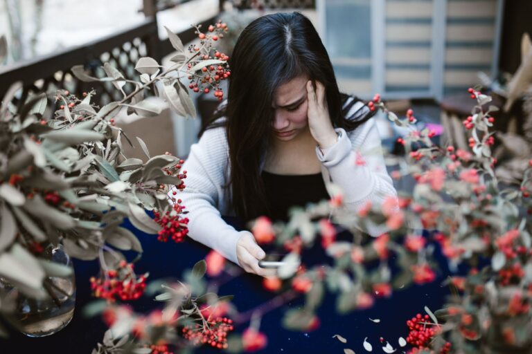 Mulher olhando para o celular com expressão preocupada
