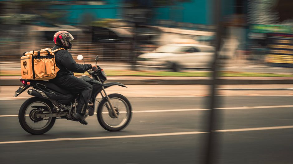 Entregador de aplicativo em motocicleta na cidade