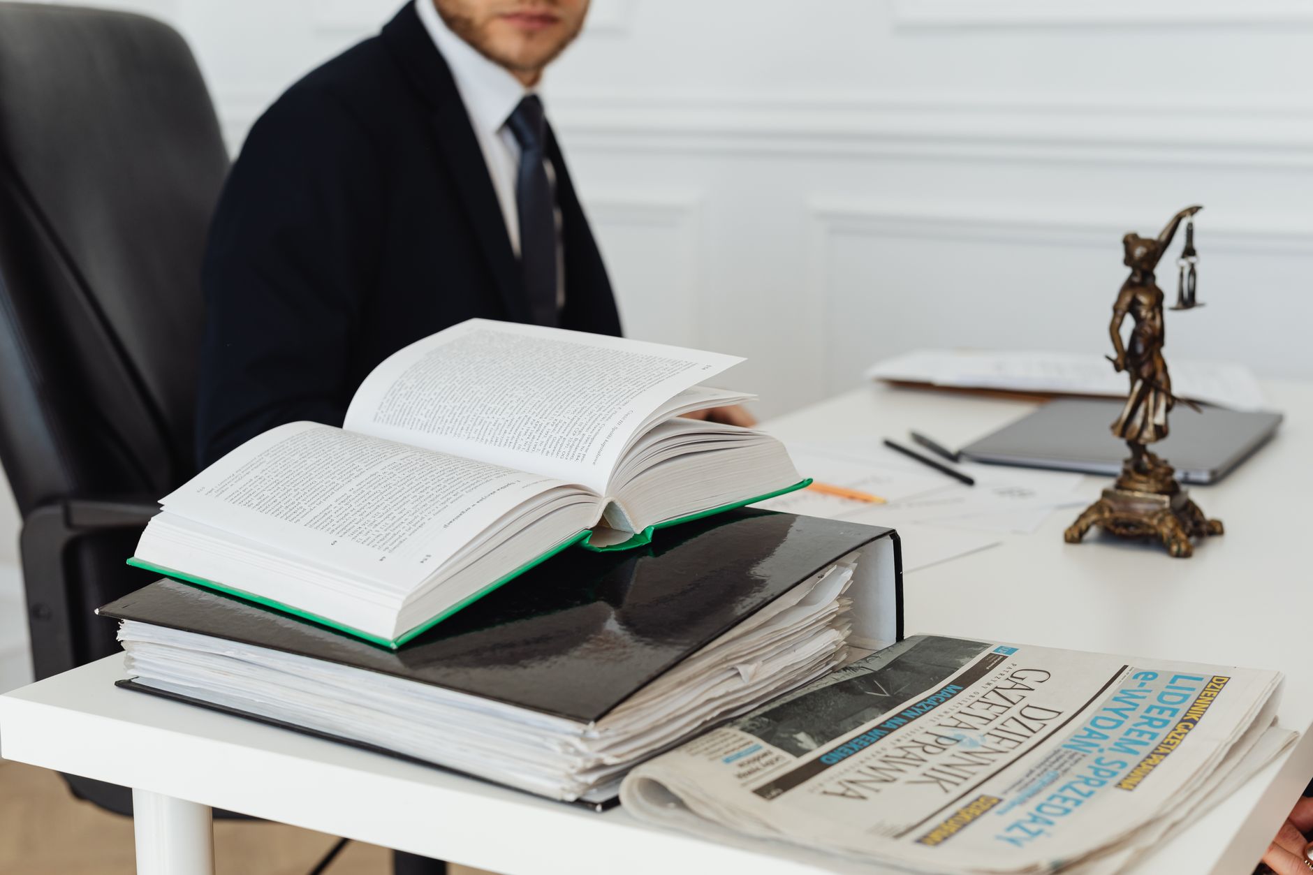 Advogado analisando processo trabalhista com livros e documentos sobre a mesa