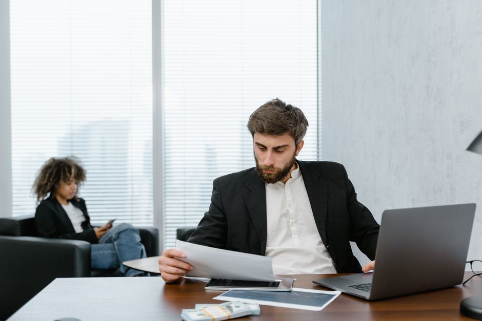Bancário analisando relatórios financeiros no escritório