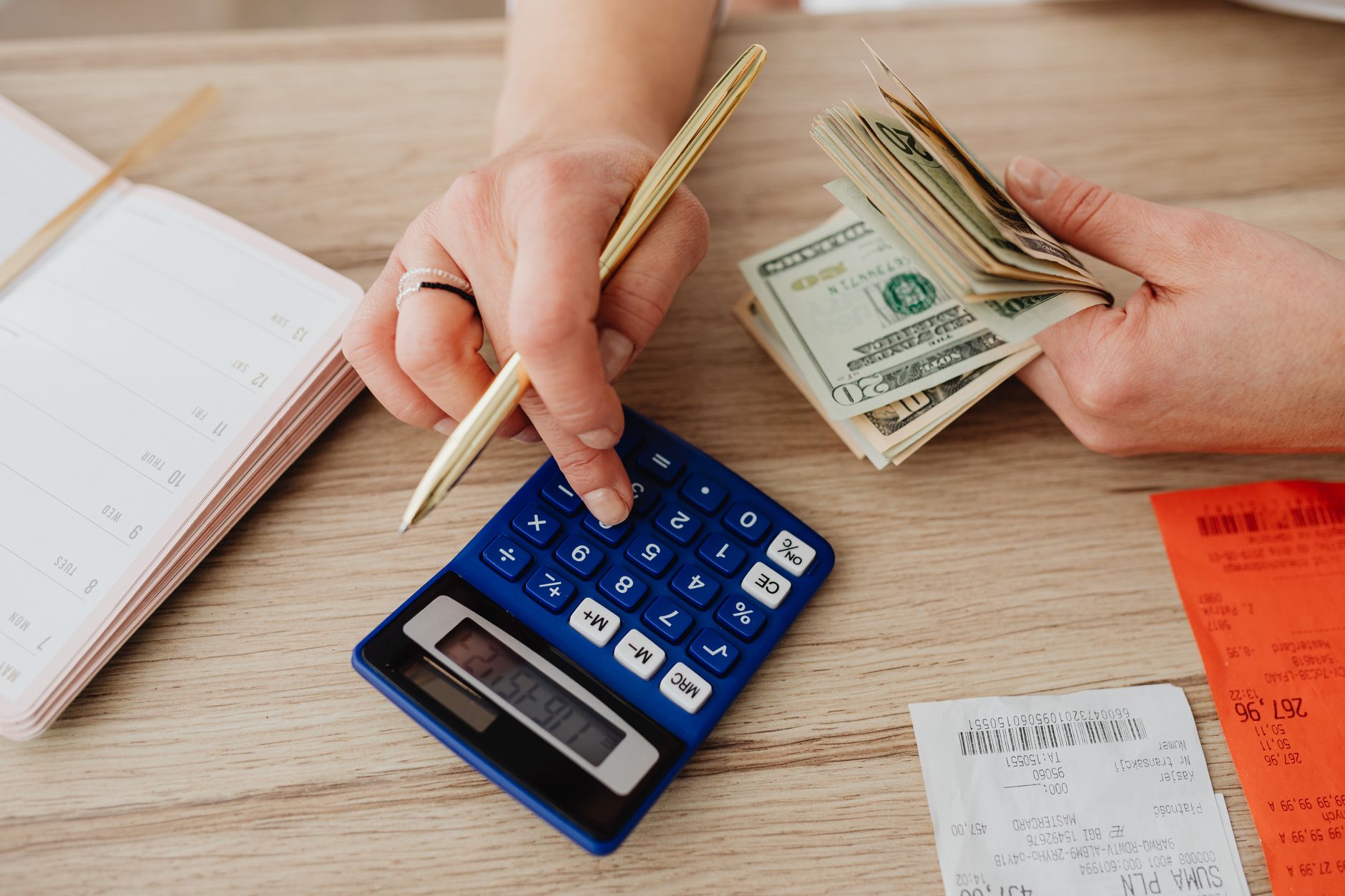 Maos com dinheiro e calculadora sobre a mesa fazendo o calculo do lucro do FGTS 2026