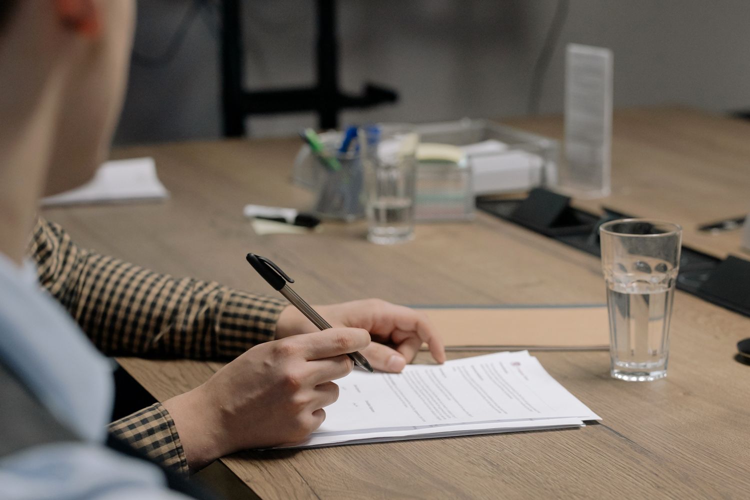 Duas pessoas analisando e assinando documento de rescisão em escritório