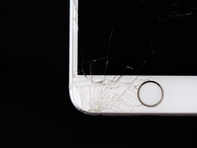 Tela de celular trincada sobre superfície