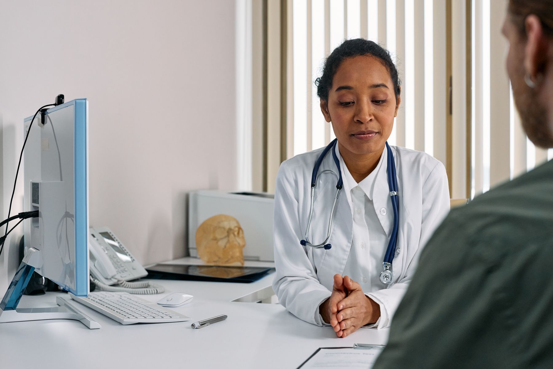 Médica conversa com paciente durante consulta clínica