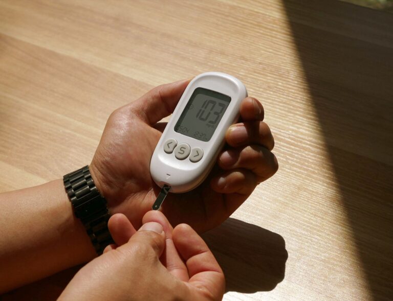 Pessoa medindo a glicemia com glicosímetro durante o expediente de trabalho