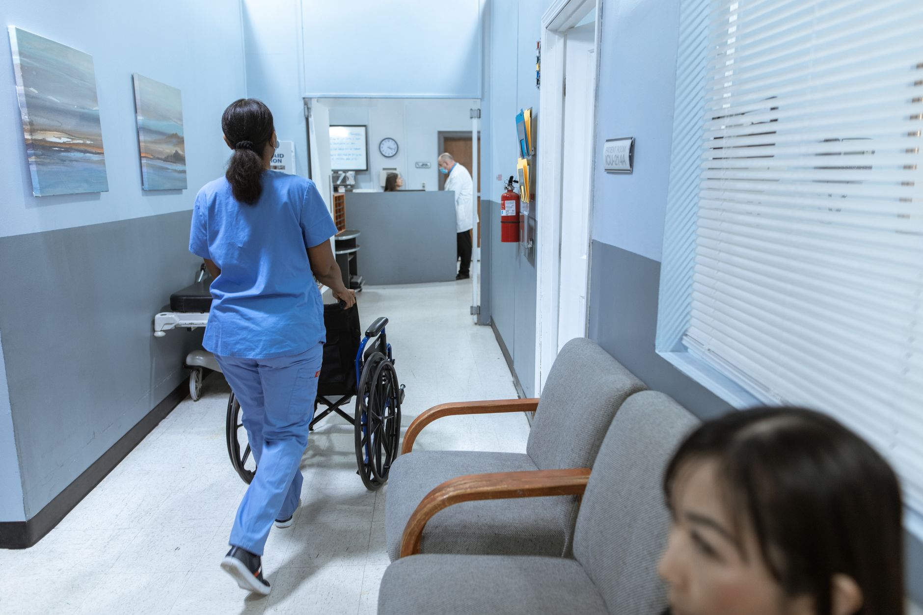 Profissional de enfermagem em corredor de hospital durante expediente de trabalho