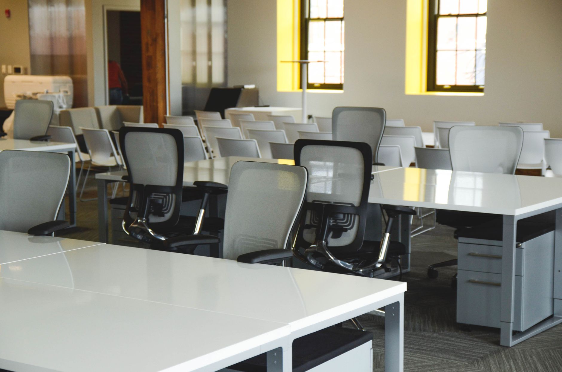 Escritorio amplo e vazio com mesas e cadeiras, representando empresa que encerrou as atividades
