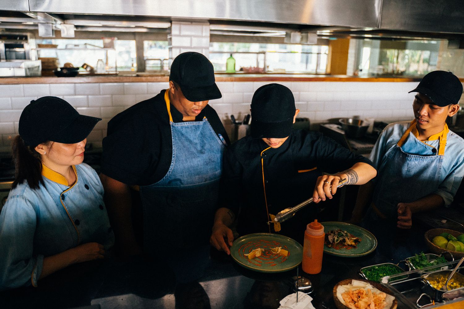 Equipe de restaurante trabalhando em conjunto na cozinha e no salão