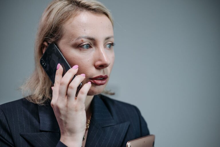 Mulher gravando conversa no celular durante reunião de trabalho