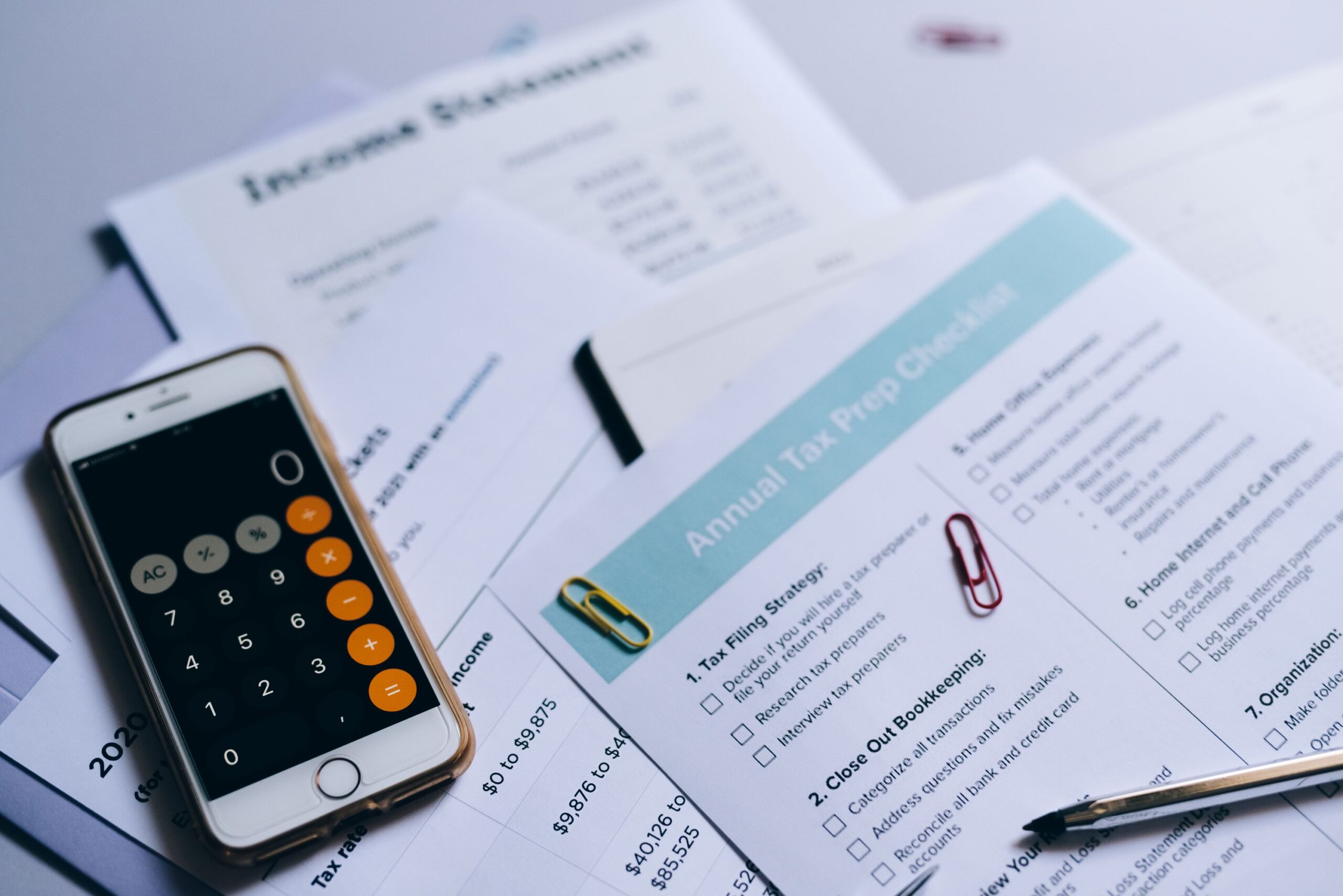 Calculadora e documentos fiscais sobre a mesa para conferência do imposto de renda