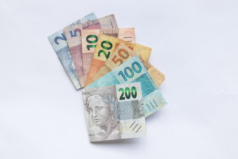 Notas de real brasileiro organizadas em leque sobre superfície branca