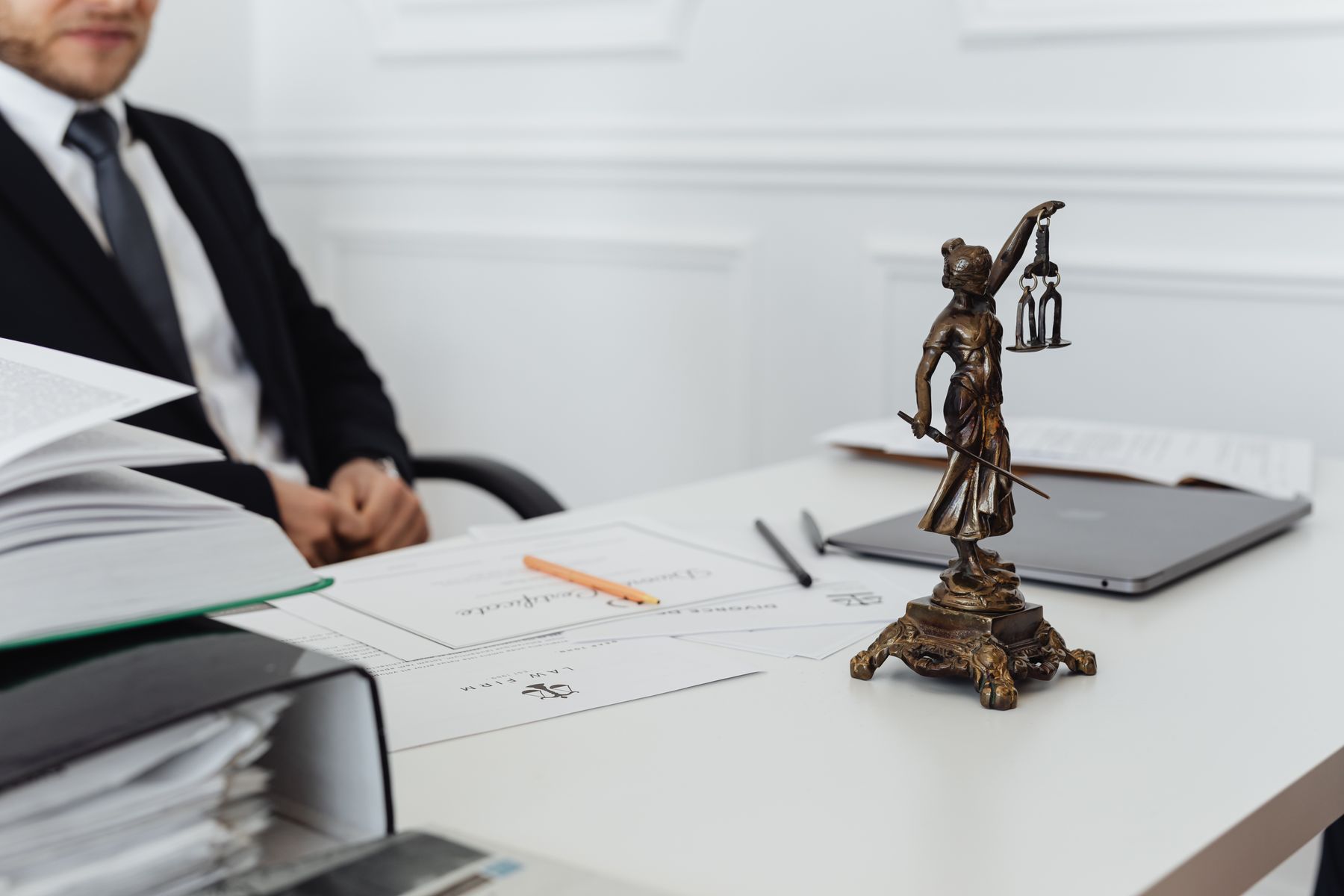 Ambiente de trabalho de advogado com símbolo da justiça, documentos e notebook
