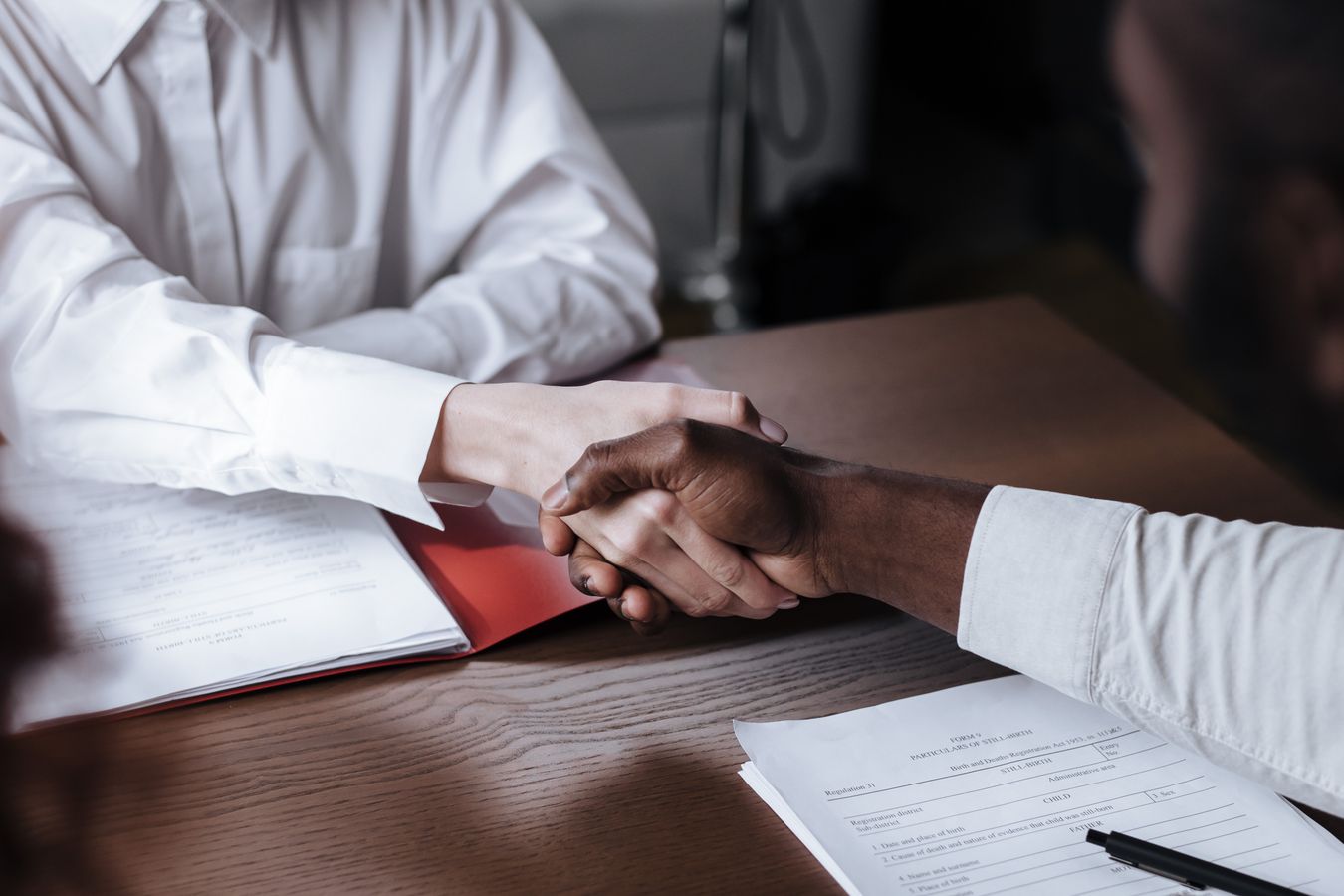 Aperto de mãos entre empregado e empresa sobre documentos