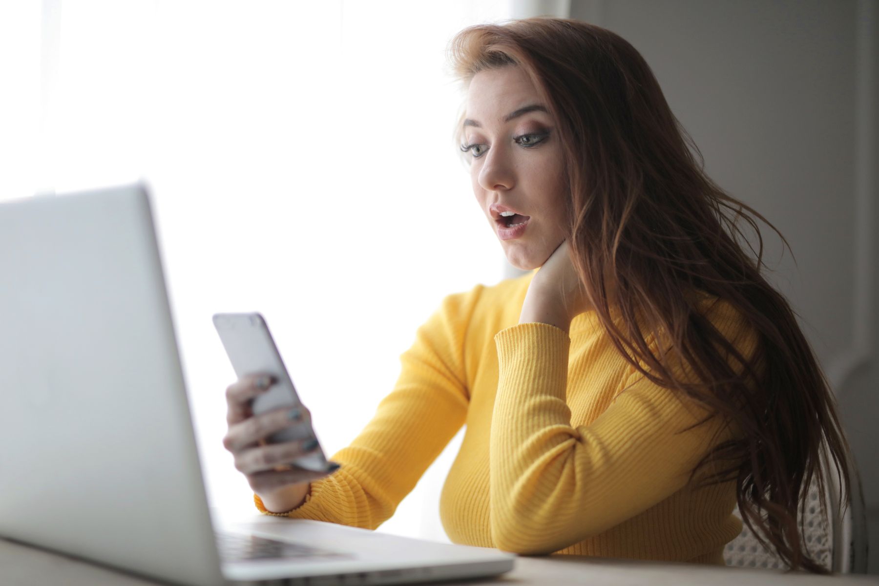 Mulher olhando notificação de pedido de amizade em rede social no celular no trabalho