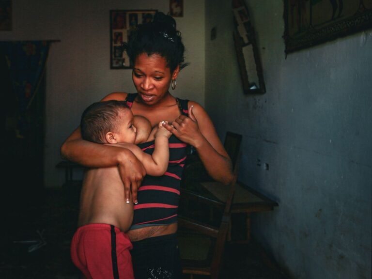 Mãe trabalhadora amamentando o bebê durante pausa do trabalho