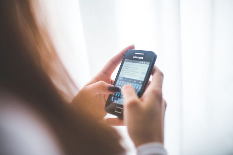 Mulher digitando mensagem no celular, guardando prints de conversa como prova