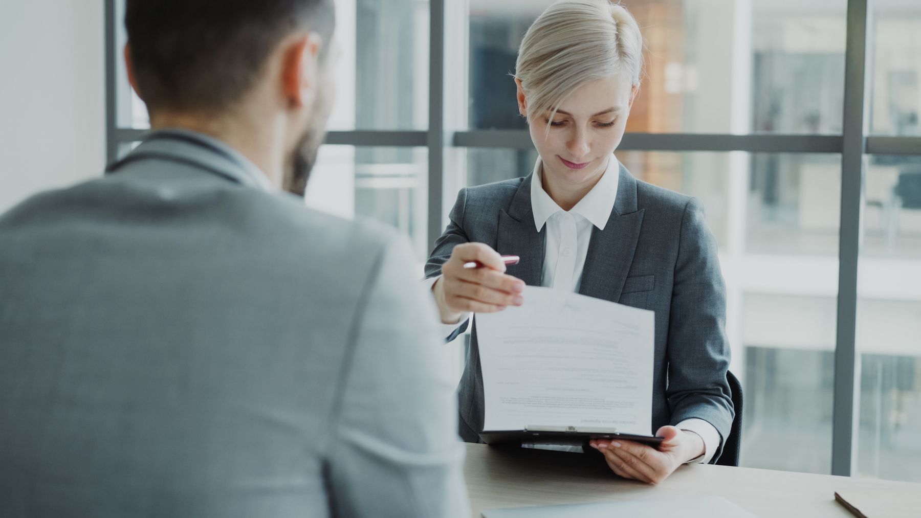 Profissionais analisam contrato e documentos sobre a mesa