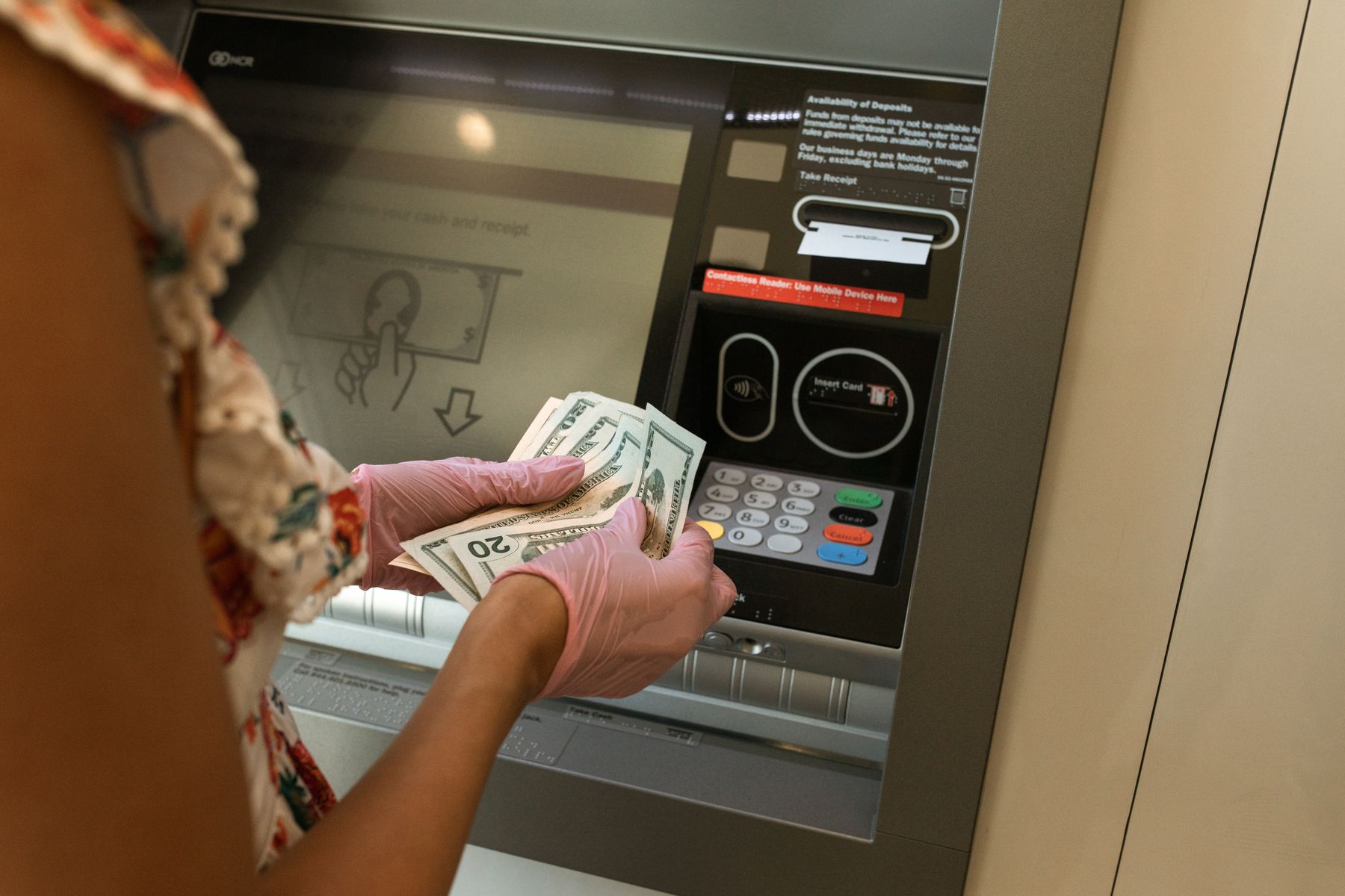 Pessoa realizando saque em caixa eletrônico de banco