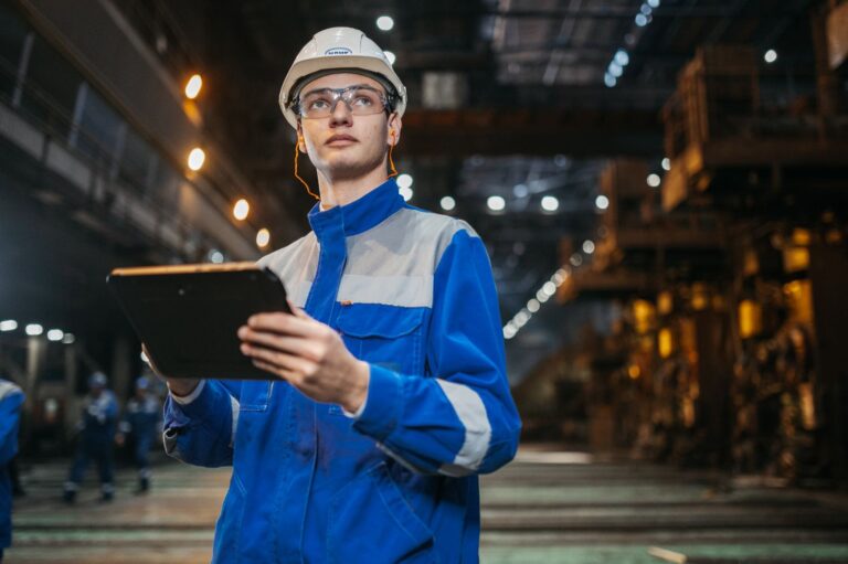 Supervisor orienta trabalhador de colete de seguranca em ambiente industrial