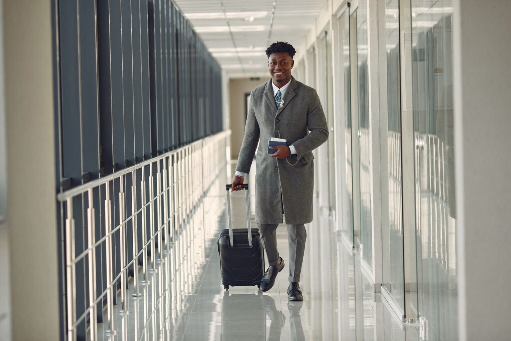 Executivo com mala de viagem caminhando no aeroporto a caminho de viagem a trabalho