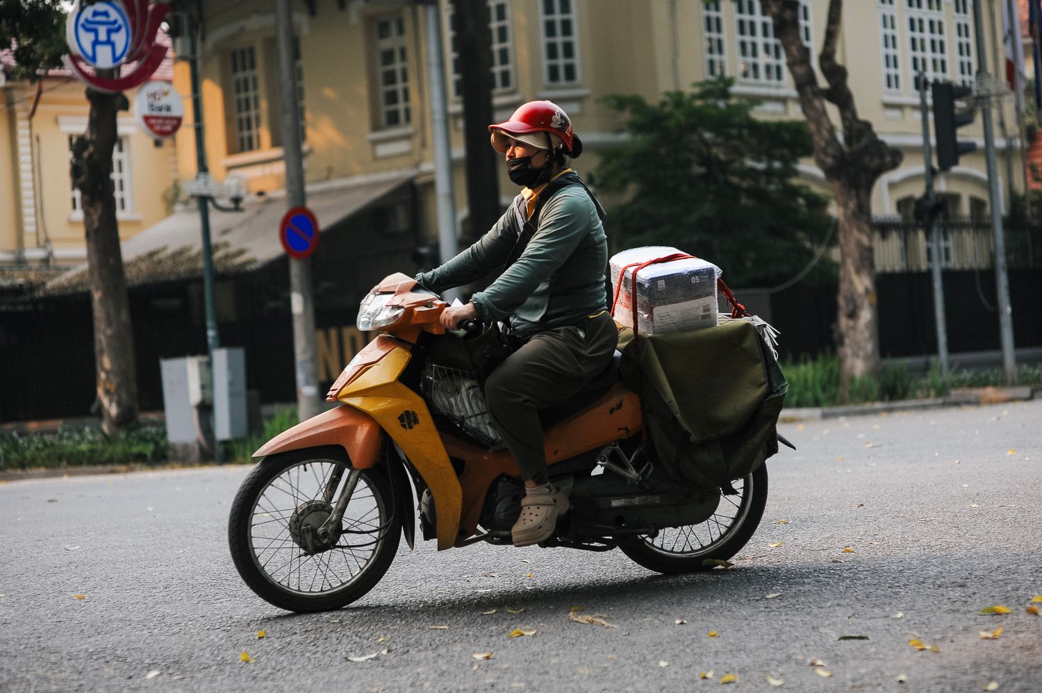 Entregador de aplicativo andando de moto pela cidade