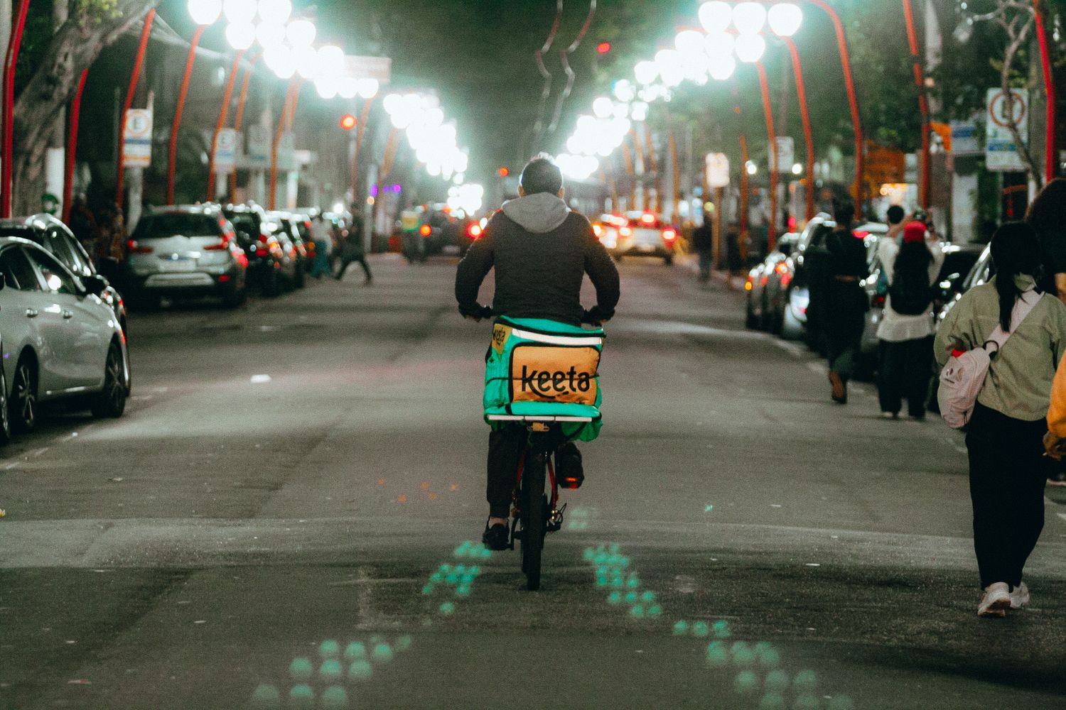Entregador de bicicleta faz entrega durante a noite na cidade
