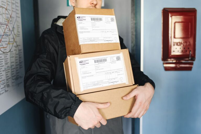 Entregador carregando pacotes para entrega, representando trabalho de carteiro