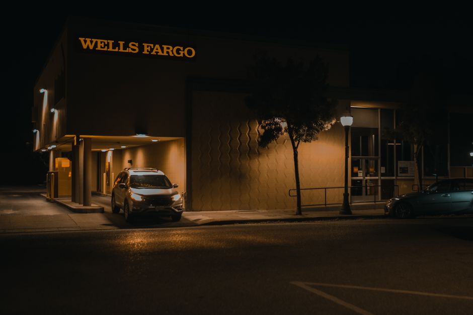 Fachada iluminada de agência bancária à noite