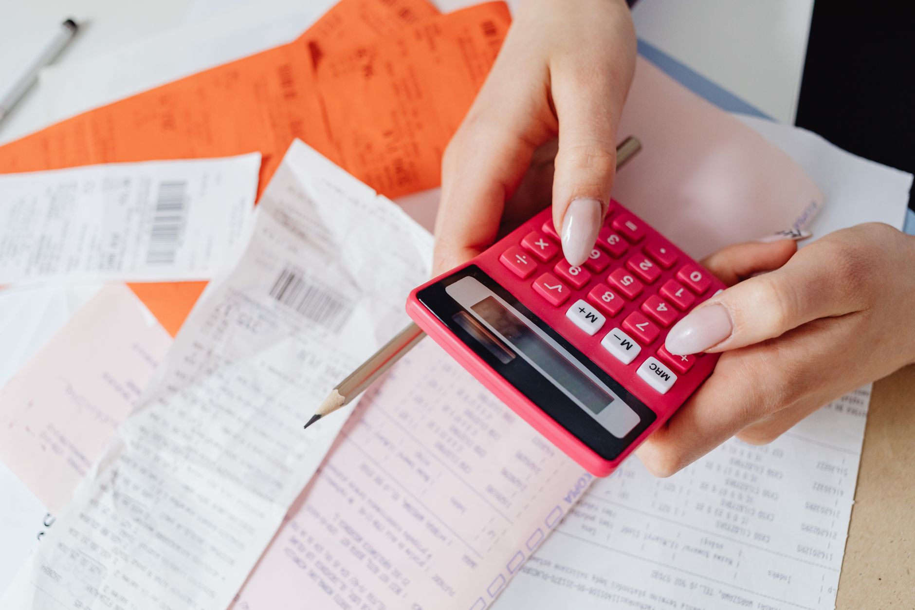 Trabalhador calculando valores e organizando documentos com calculadora
