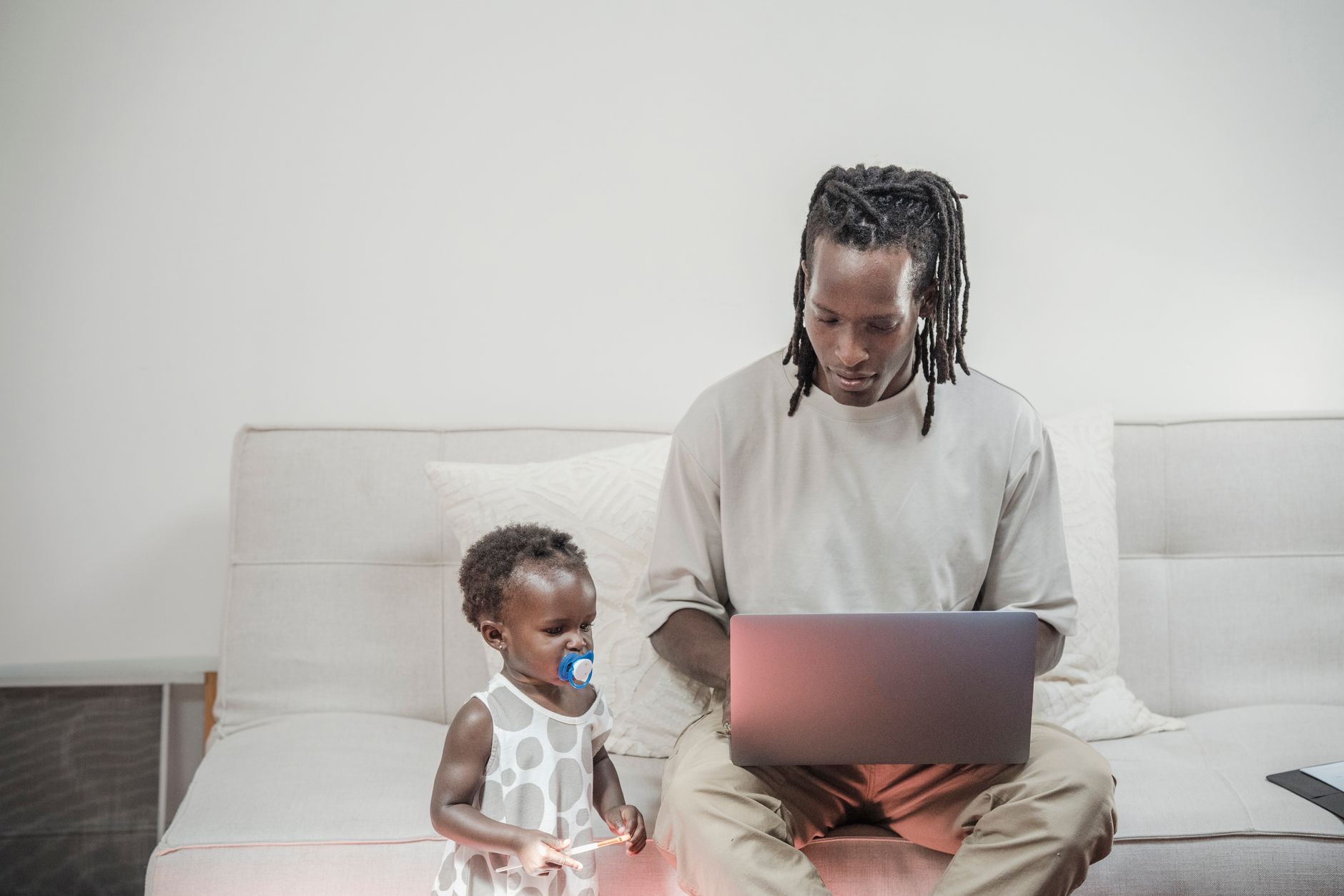 Pai trabalhando em home office ao lado de material de terapia infantil