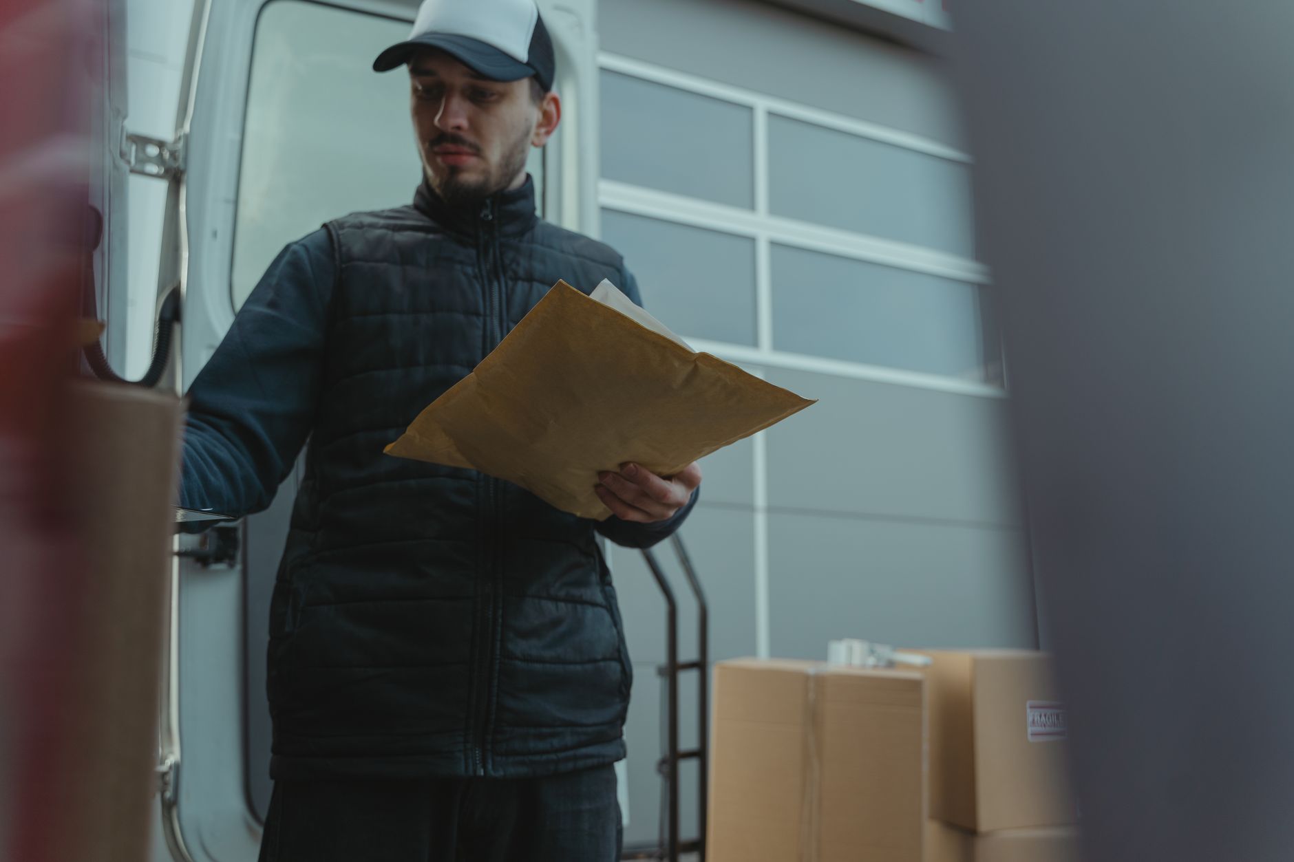 Entregador organizando encomendas ao lado de van de distribuição