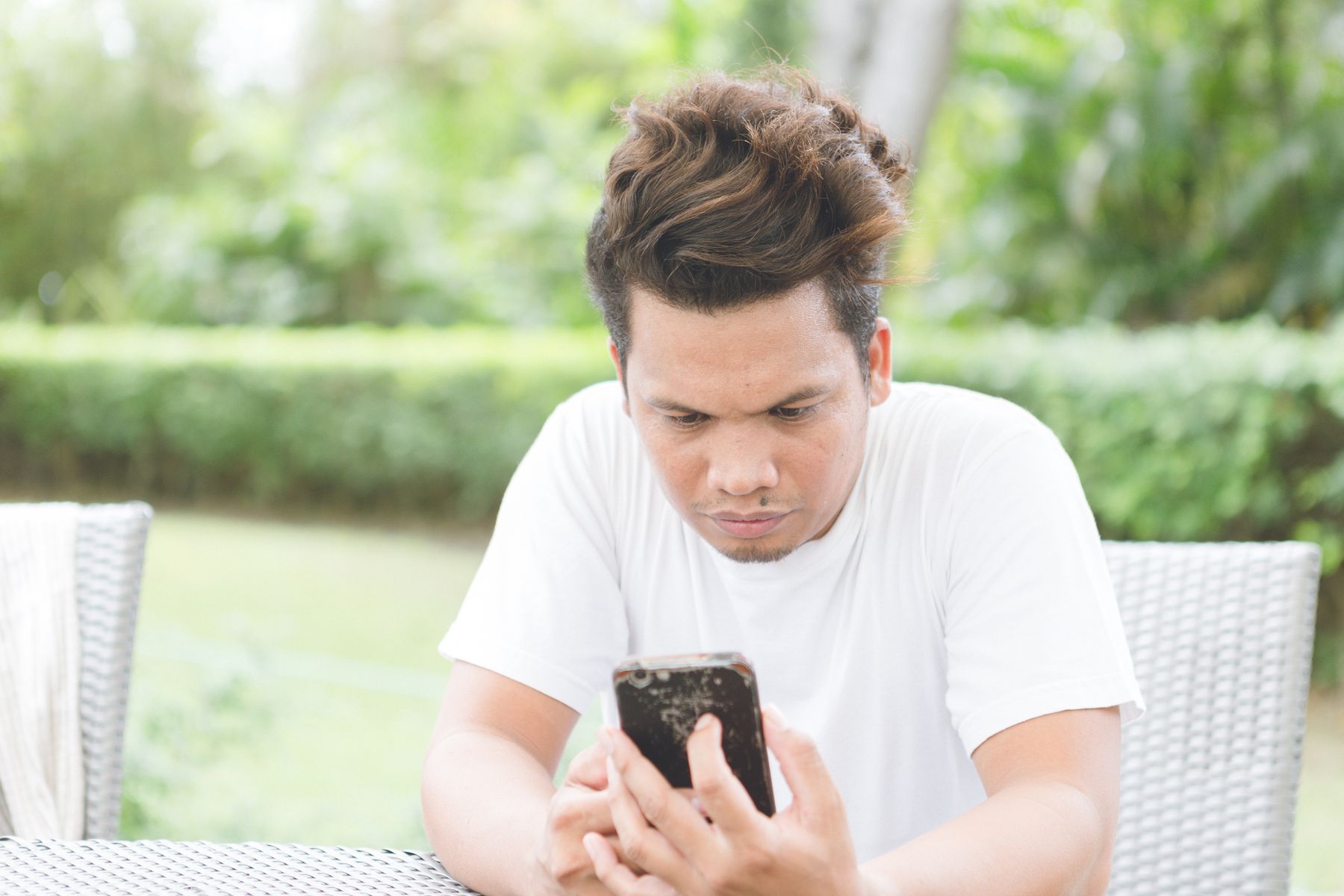 Trabalhador concentrado lendo mensagem de demissão no celular