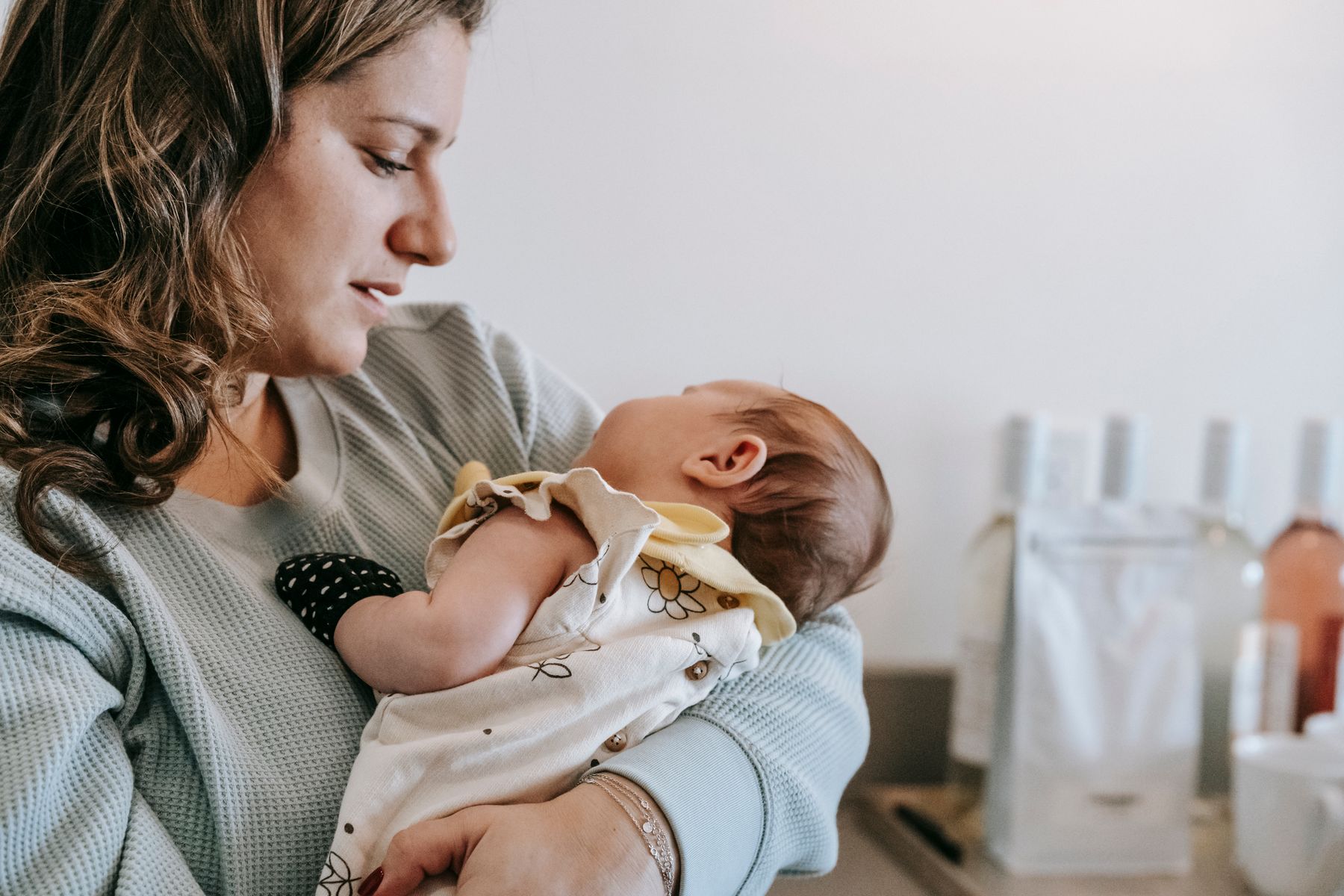 Mãe segurando bebê recém-nascido no colo
