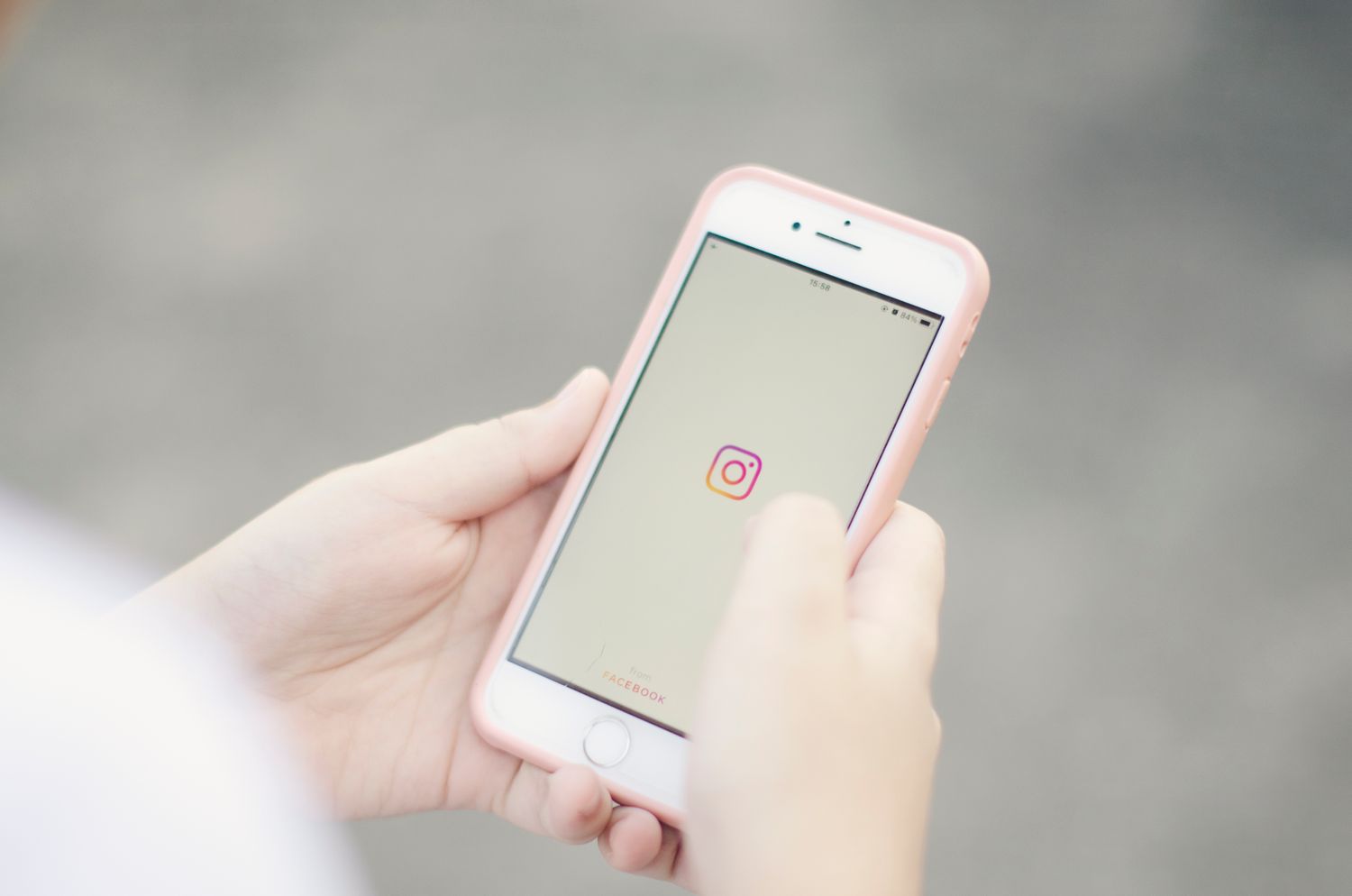 Mãos segurando celular durante navegação em rede social