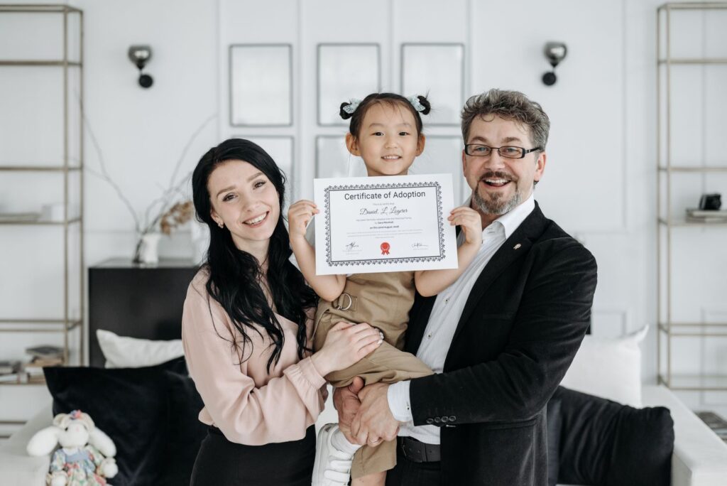 Família comemorando adoção com certificado nas mãos