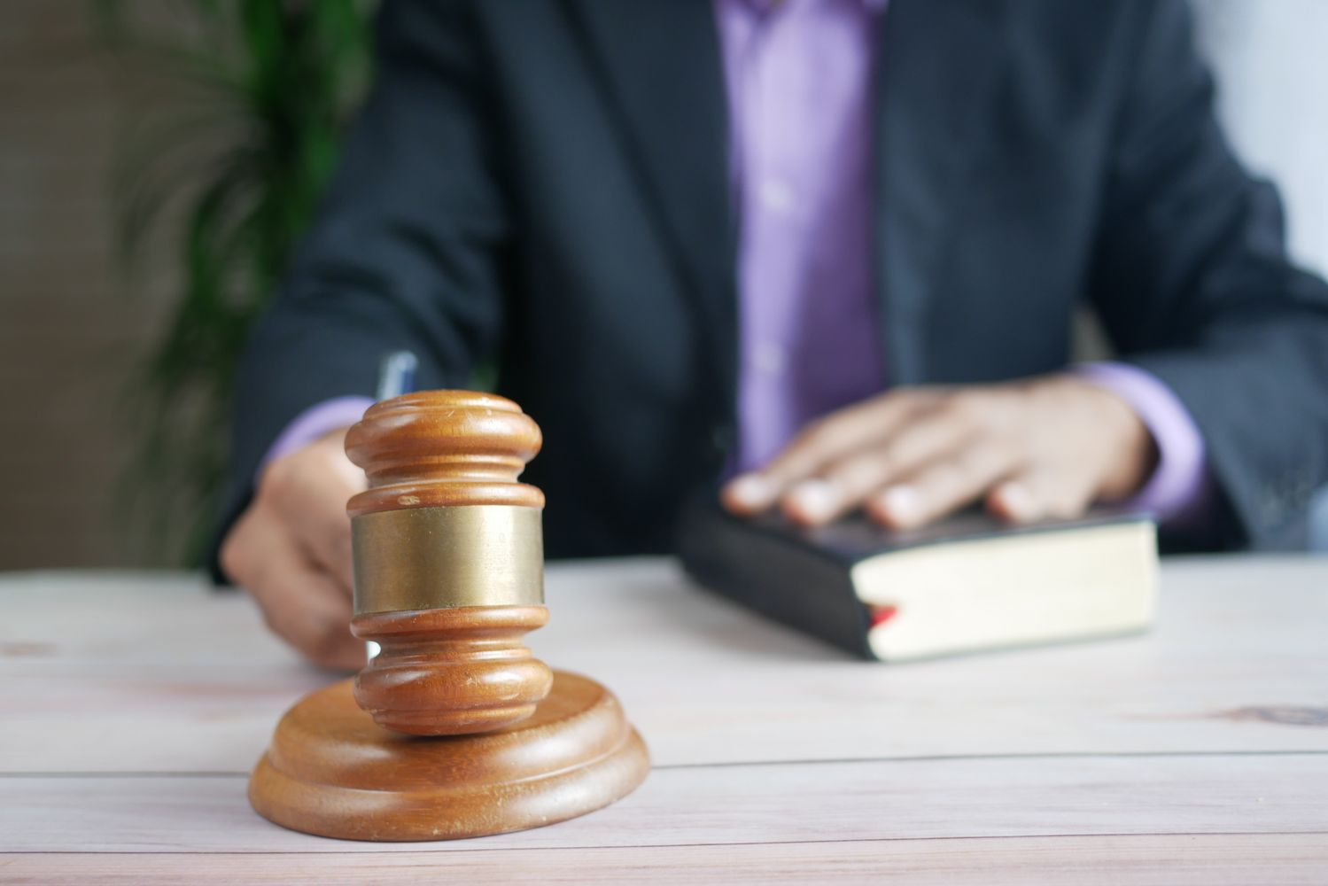 Martelo de juiz e livros de direito sobre a mesa, representando decisões da Justiça