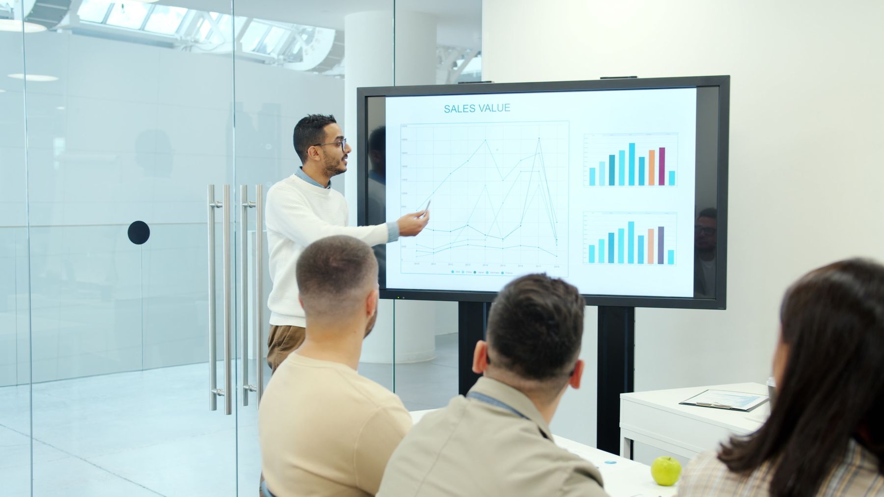 Equipe de vendas analisando gráfico de desempenho e ranking de resultados