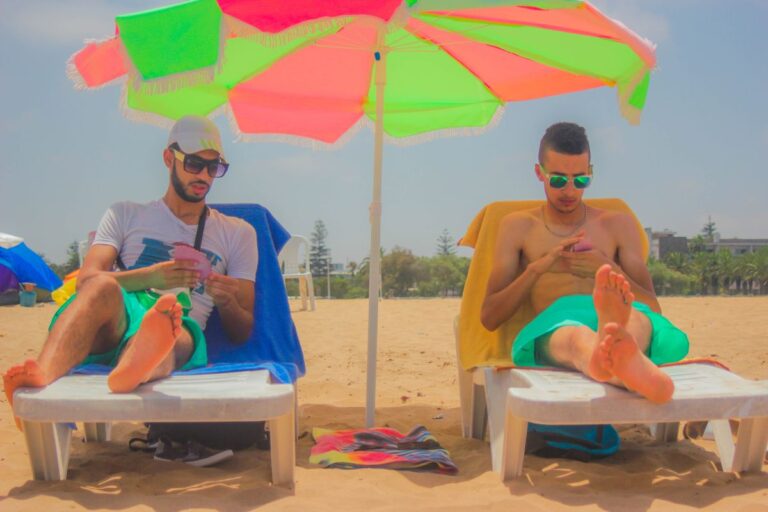 Dois homens descansando em espreguiçadeiras na praia