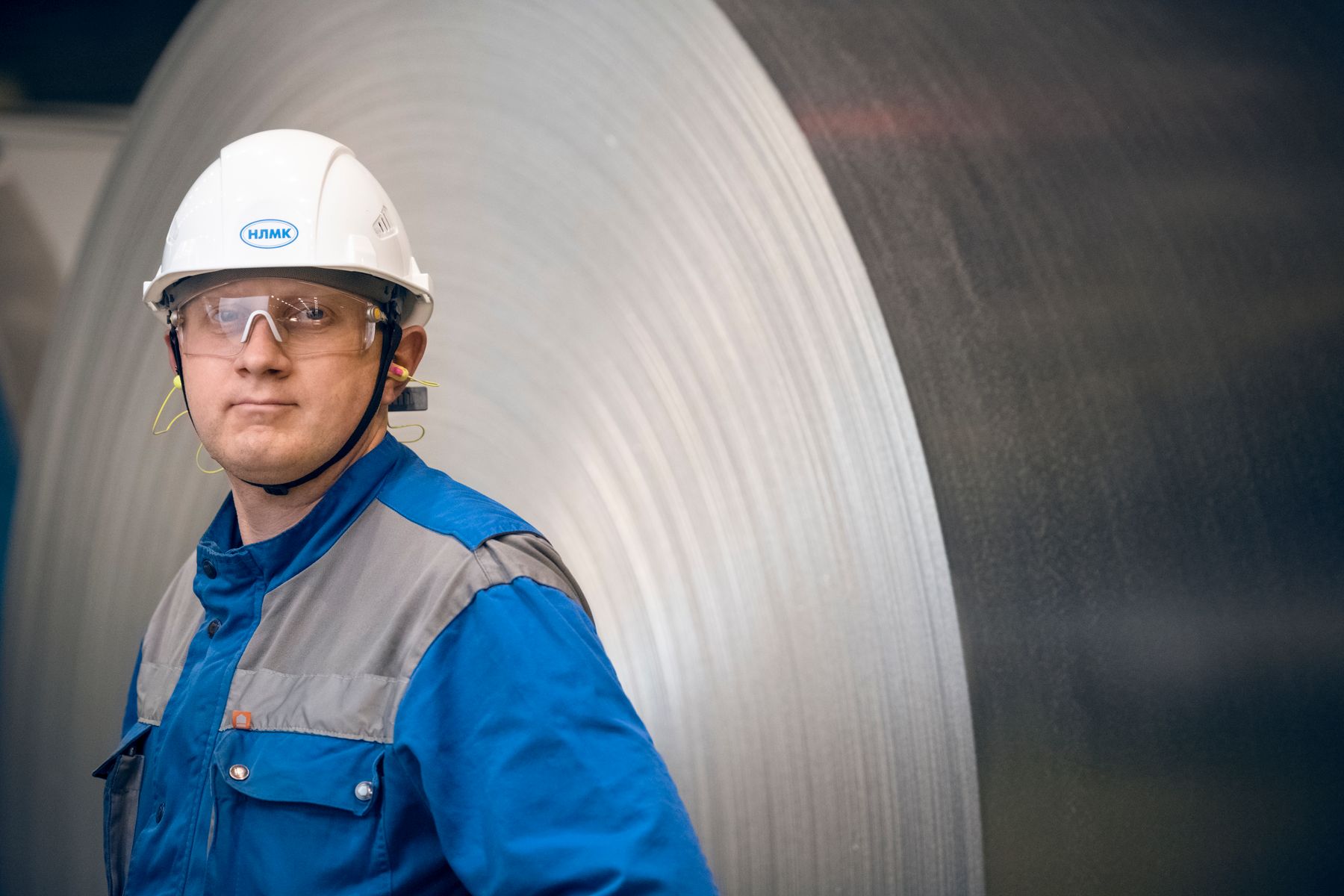 Trabalhador de fábrica com equipamento de proteção em ambiente industrial ruidoso