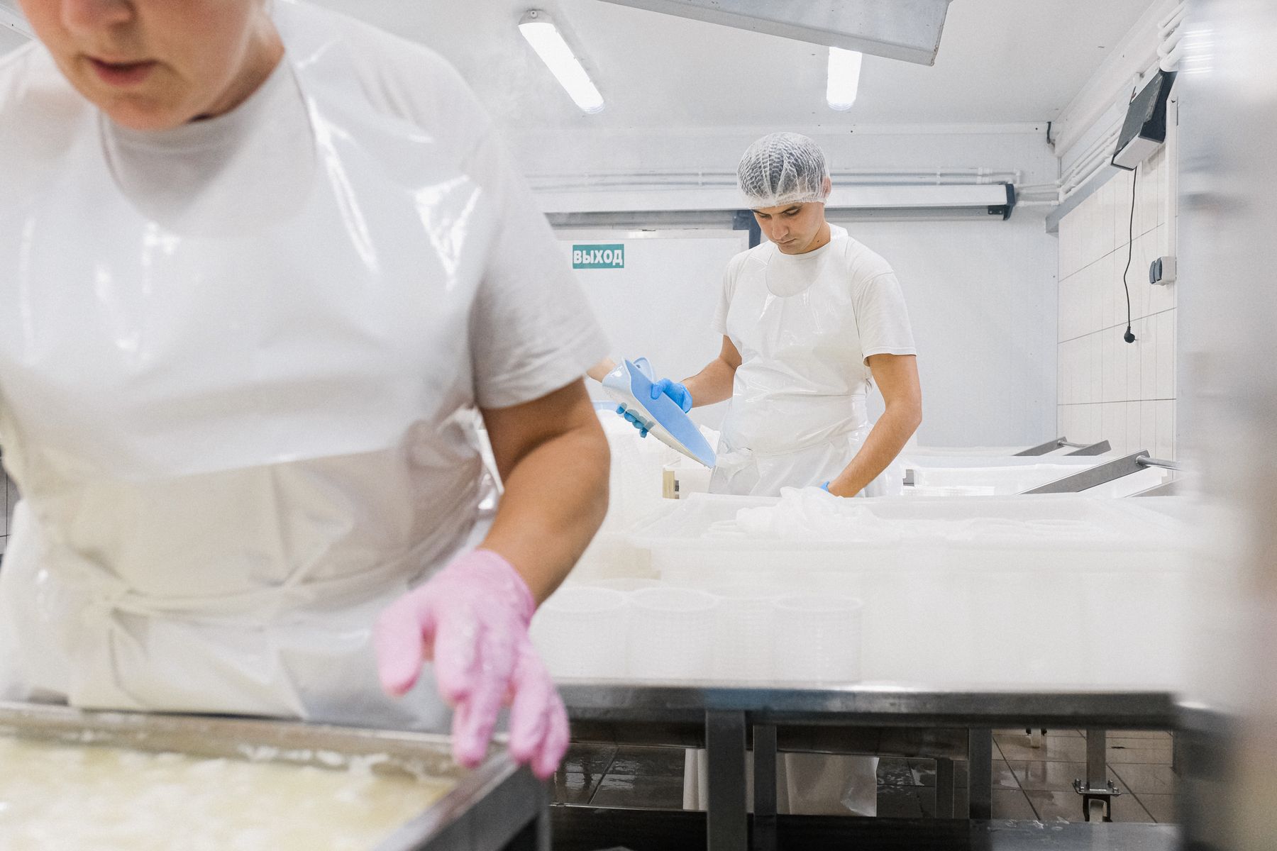 Trabalhadores de uniforme em linha de produção de fábrica de alimentos