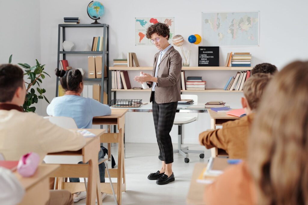Professora ministrando aula para alunos atentos em sala de aula