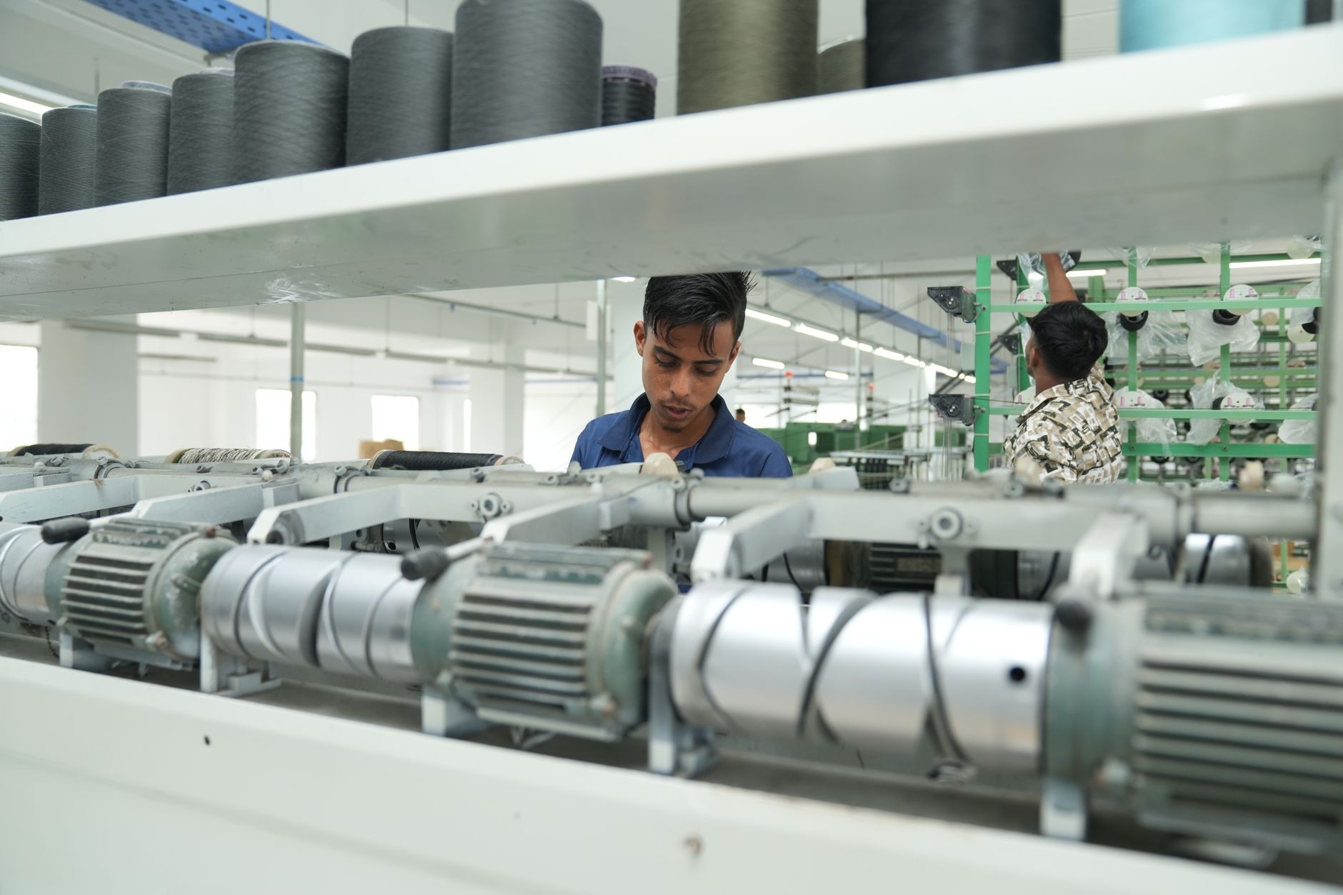Operário trabalhando ao lado de máquina industrial em fábrica