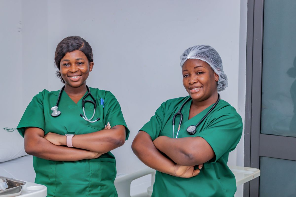 Duas enfermeiras sorrindo em quarto de hospital