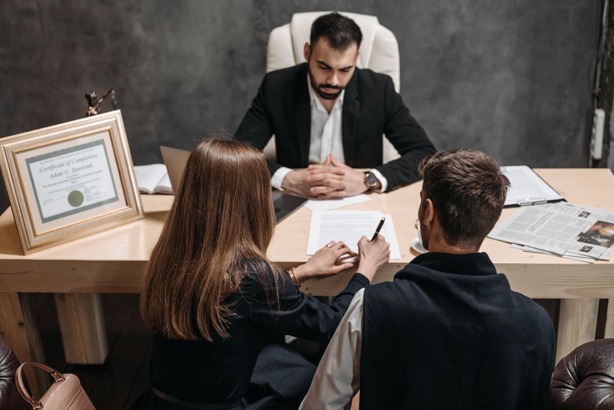 Advogada conversando com clientes sobre documentos em escritório