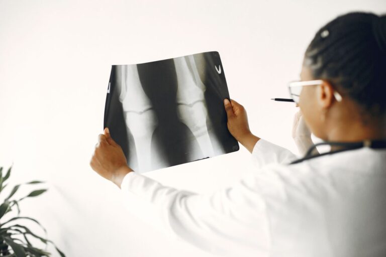 Médico examinando radiografia de joelho de paciente