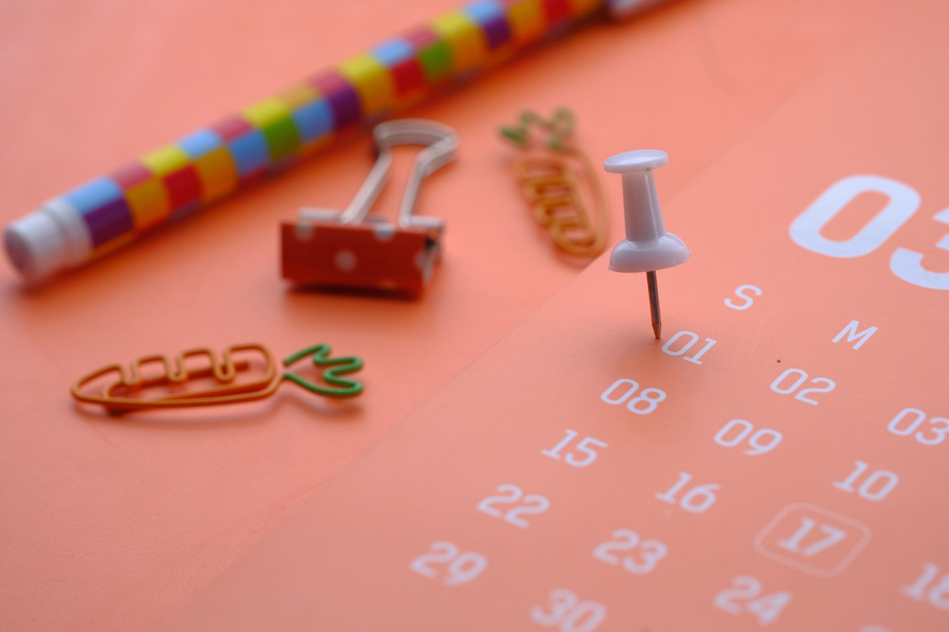 Calendário e materiais de escritório sobre a mesa, representando o controle de faltas e dias de descanso